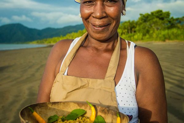 A woman with produce in the Pacific Forest Communities, Colombia.