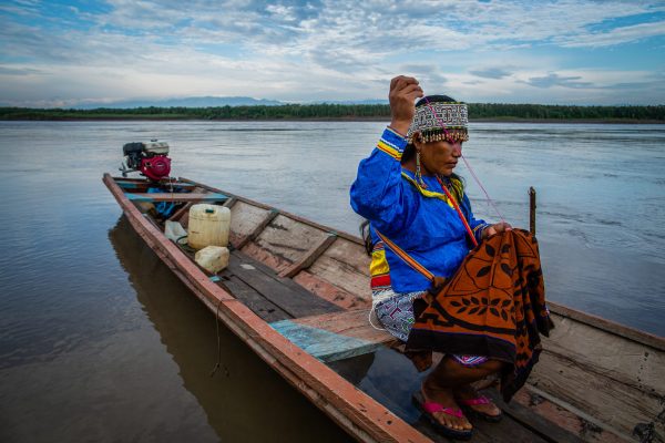 A woman working on traditional handicraft on a canoe in Nii Kaniti, Peru.